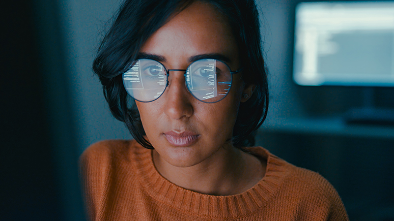 reflection of a screen on a woman's glasses